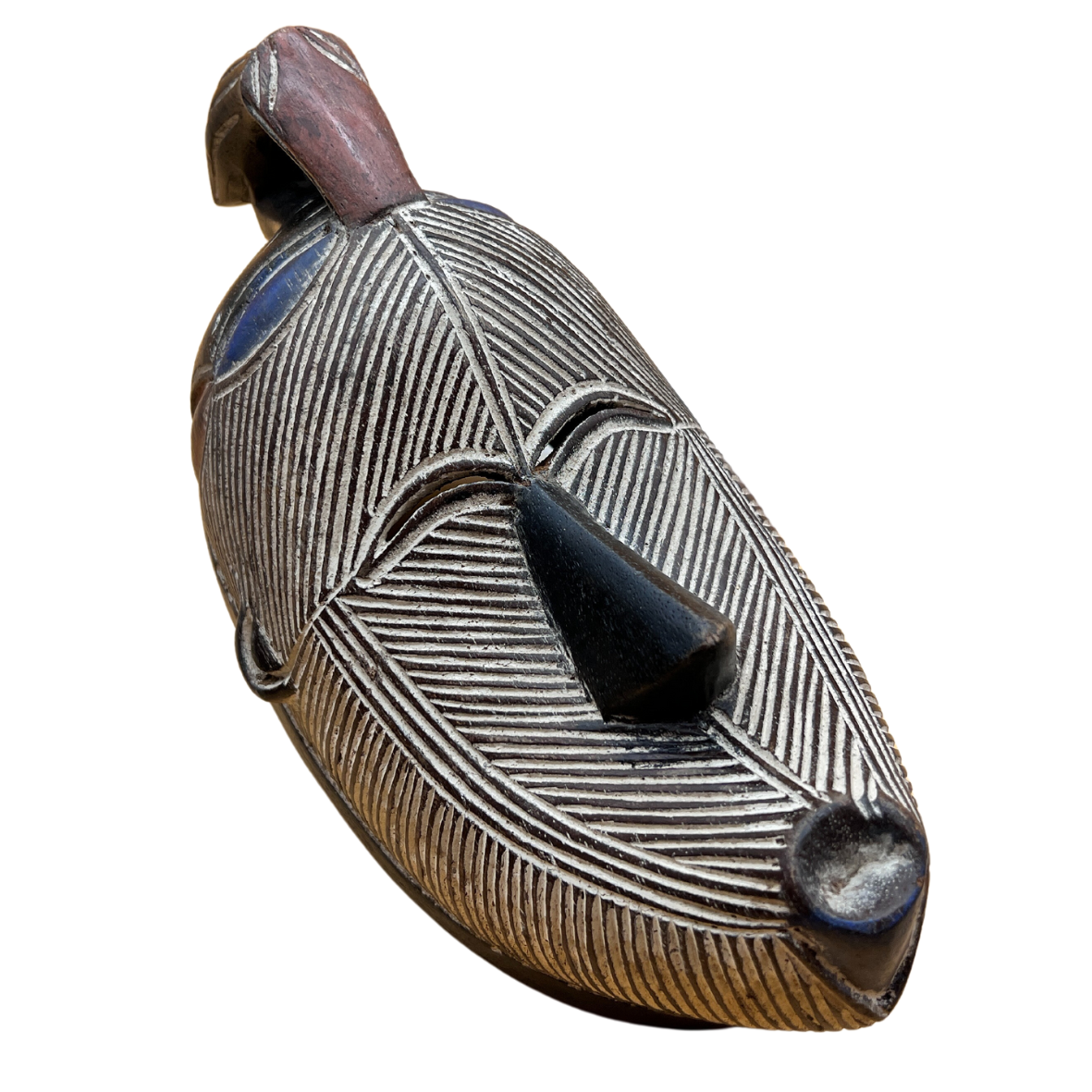 Máscara tribal de madeira com linhas gravadas e detalhes coloridos