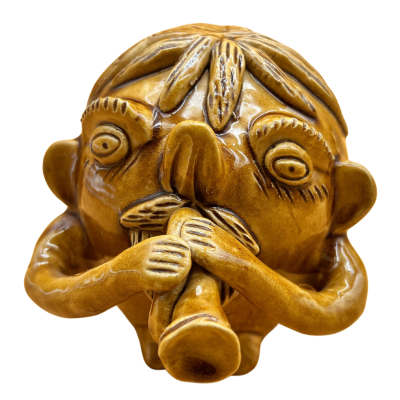 Escultura de cerâmica castanha de personagem a tocar instrumento de sopro