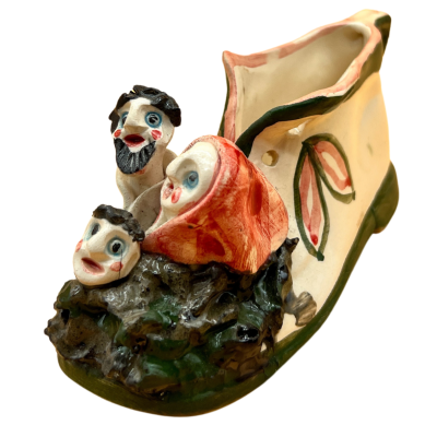 Figura decorativa em cerâmica com forma de sapato e três rostos caricaturais