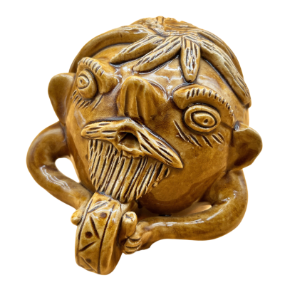 Objeto decorativo em cerâmica castanha em forma de cabeça humana estilizada