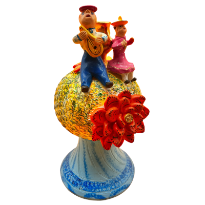 Escultura cerâmica colorida com figuras humanas e flor vermelha