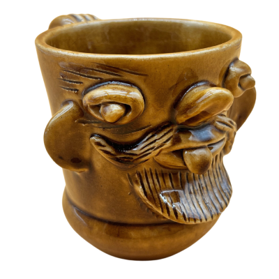 Caneca de cerâmica castanha com rosto em relevo