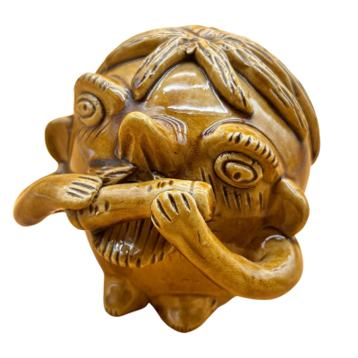 Figurinha de madeira castanha esculpida com rosto caricado e mãos segurando objecto cilíndrico