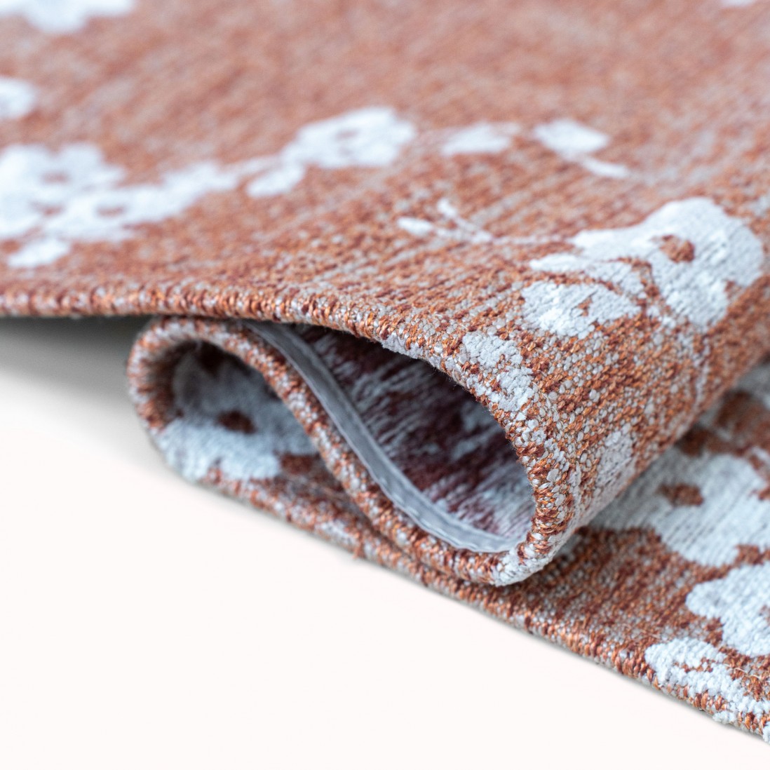 Tapete Almond Chenille Tapete floral branco em fundo castanho alaranjado enrolado