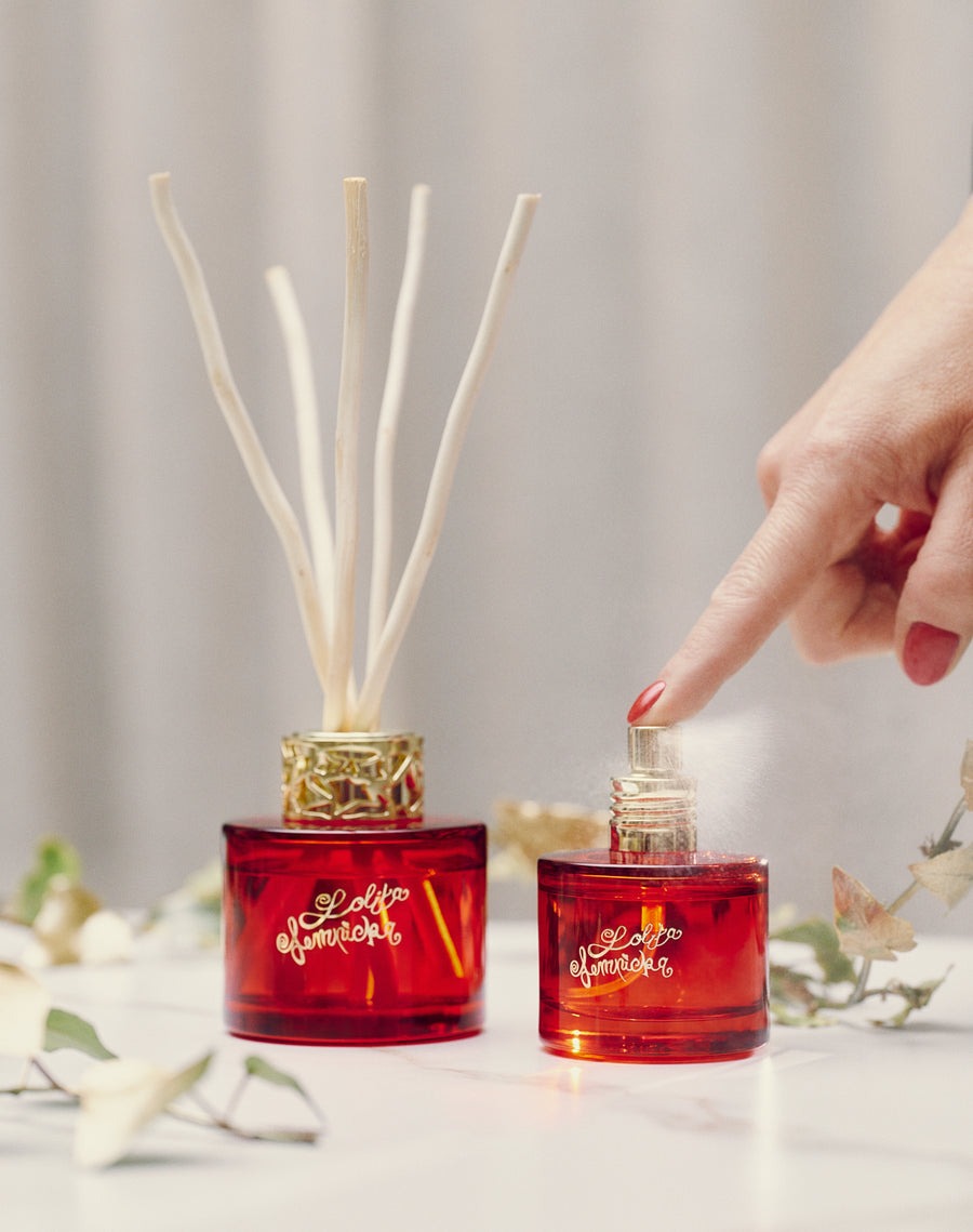 Frascos vermelhos Lolita Lempicka com difusor de varetas e spray em fundo claro