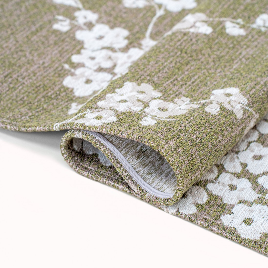 Tapete Almond Chenille Tapete tecido verde com padrão floral branco dobrado