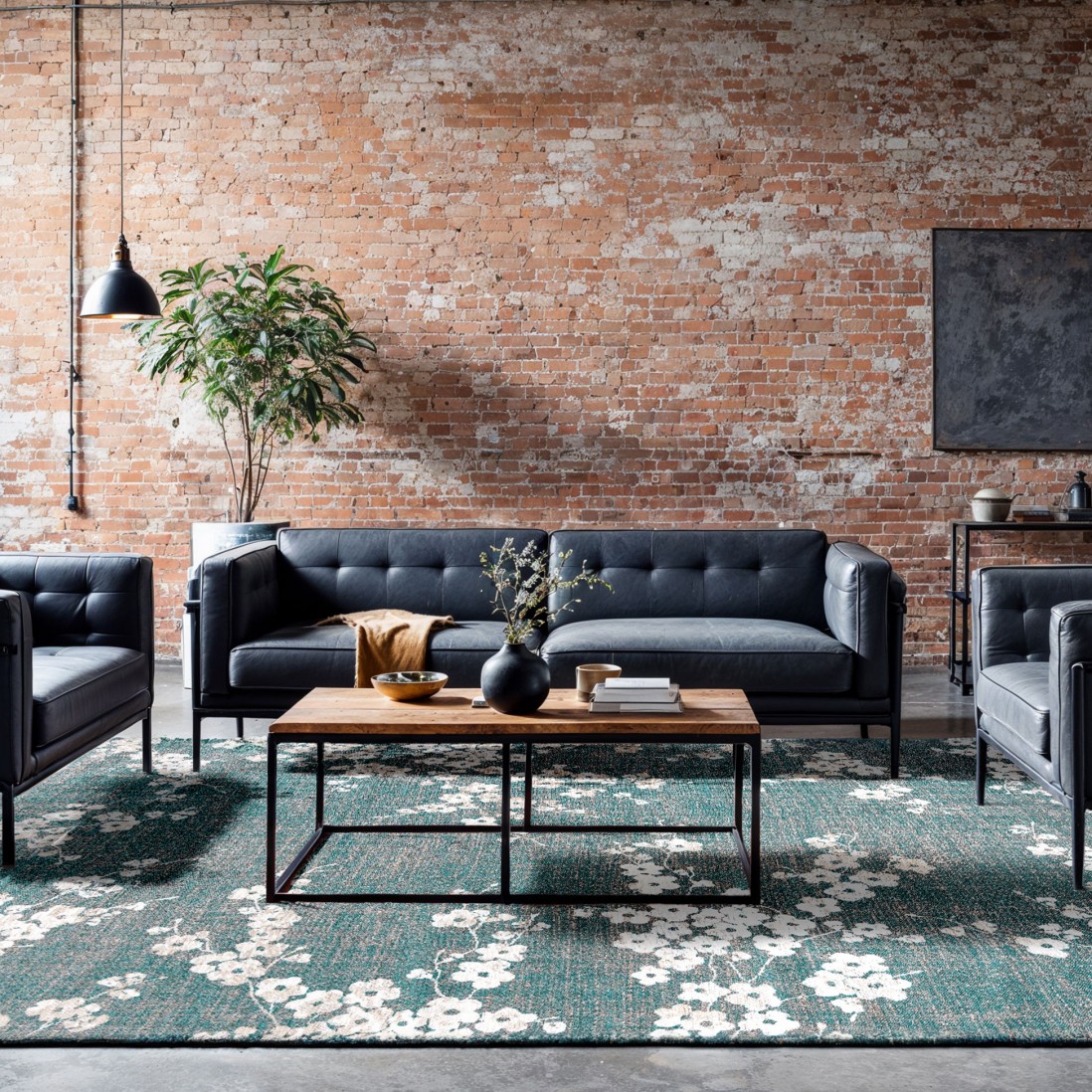 Tapete Almond Chenille Sala de estar com sofá preto, mesa de madeira e tapete floral verde