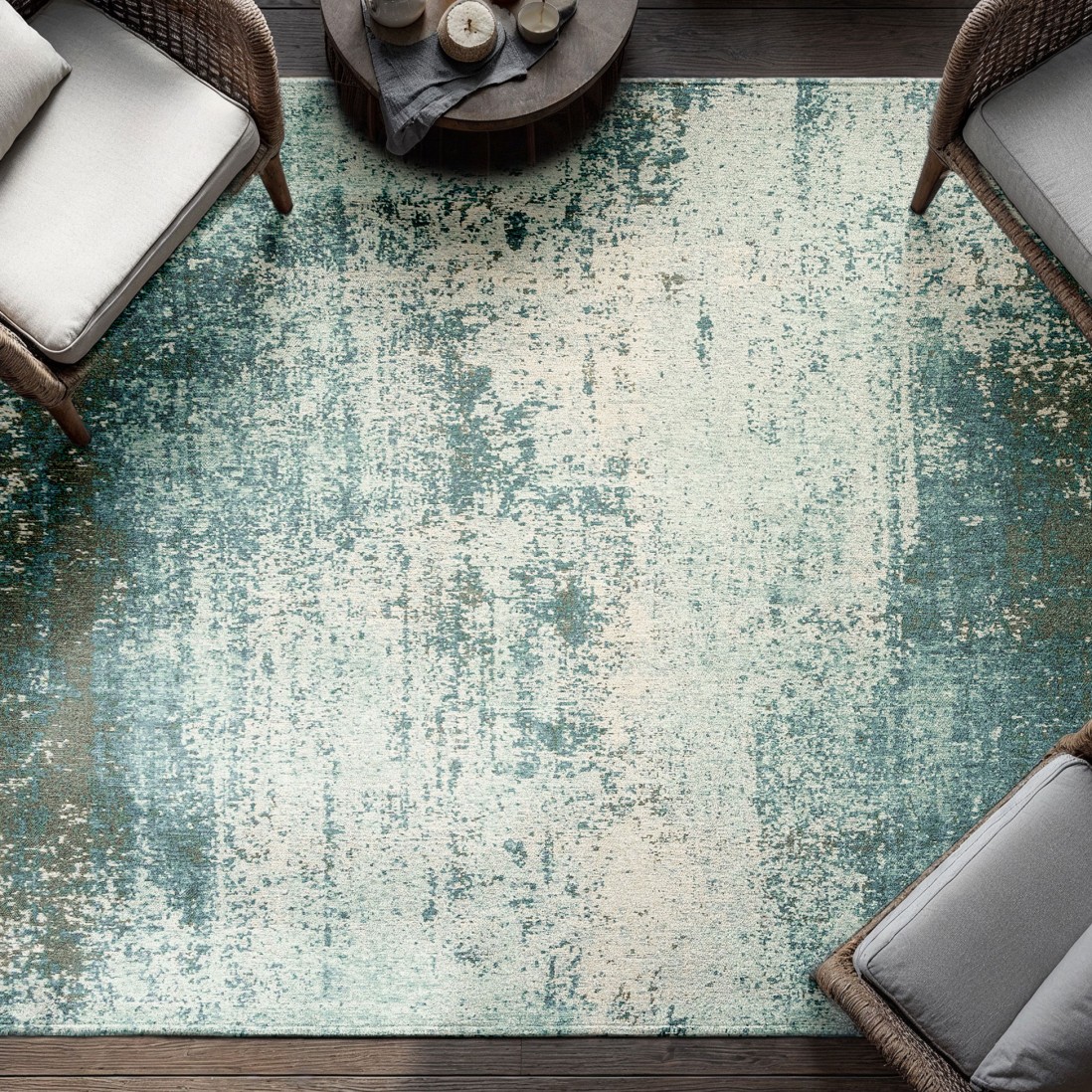 Tapete Moon Chenille Tapete azul e bege com padrão abstrato em sala com cadeiras de vime e mesa de madeira