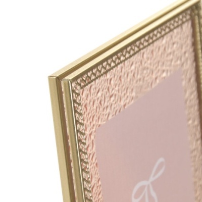 Moldura dourada texturizada com cartão rosa e laço branco