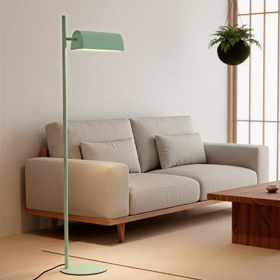 Candeeiro de pé verde claro ao lado de sofá cinza claro com mesa de madeira e planta suspensa