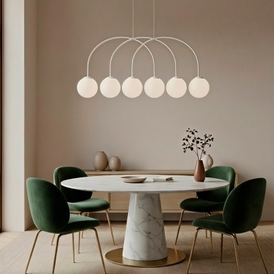 Mesa de jantar redonda em mármore com cadeiras verdes e candeeiro com globos brancos suspenso