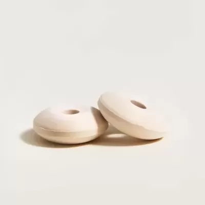 Dois rolos de madeira clara com formato circular e buraco no centro