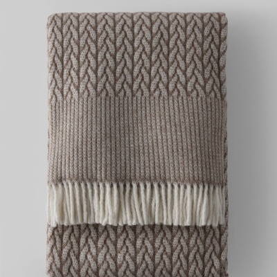 Manta de tricô castanha e creme com franjas brancas dobrada