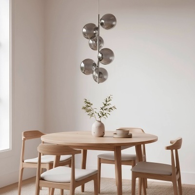 Mesa de jantar redonda em madeira clara com quatro cadeiras e lustre moderno