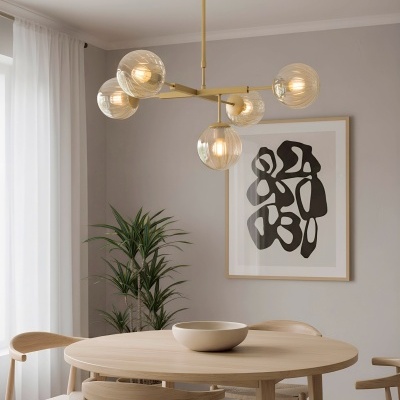 Mesa de jantar redonda de madeira clara com cadeiras e candeeiro com globos de vidro