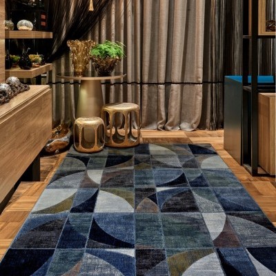 Tapete geométrico azul com mesa dourada e cadeiras em ambiente interior