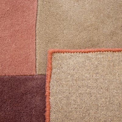 Tapete quadrado bicolor visto de cima com cantos dobrados.