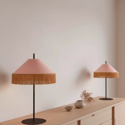 Duas lâmpadas de mesa com abajur cor de rosa e franjas douradas sobre aparador de madeira clara