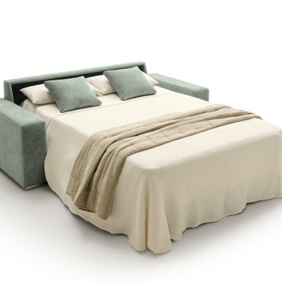 Sofá-cama cinza claro com almofadas verdes e brancas, colcha creme e cobertor bege