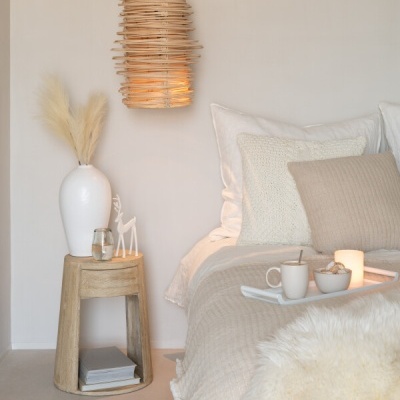 Quarto minimalista com candeeiro suspenso de rattan e mesa de cabeceira em madeira clara