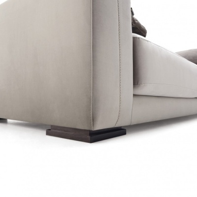 Sofá cinza claro com almofadas castanhas e pés em madeira escura