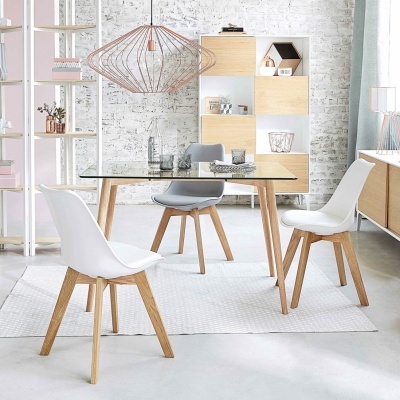 Mesa de vidro com cadeiras modernas brancas e cinza, estante e parede branca de tijolos