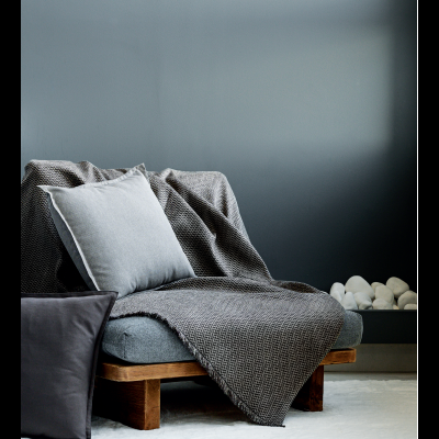 cadeira de madeira com almofada cinza e manta cinza escuro