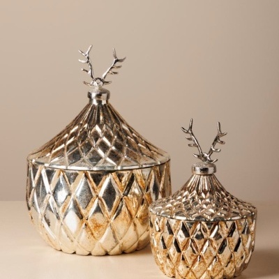 Duas caixas decorativas douradas com padrões em losango e tampas com antlers prateados