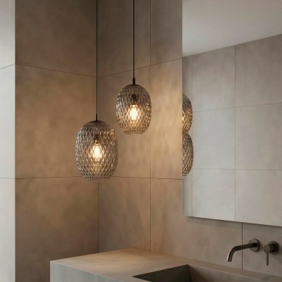 Candeeiros suspensos com abajures em vidro cinza geométrico numa casa de banho moderna com bancada e torneira metálica.