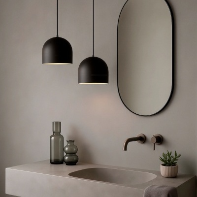 Casa de banho com lavatório bege, espelho oval, lâmpadas pretas pendentes, garrafas decorativas e planta.