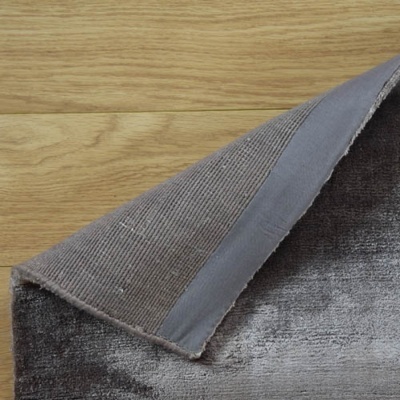 Tapete cinzento com verso antiderrapante sobre chão de madeira clara