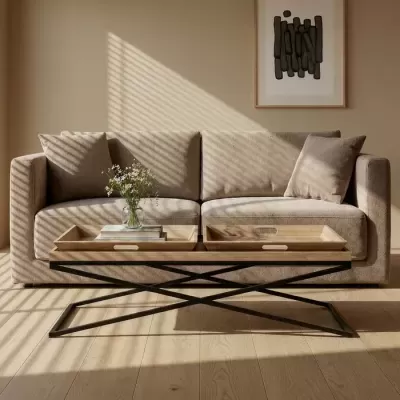 Sofá bege com mesa de centro de metal preto e bandejas de madeira clara