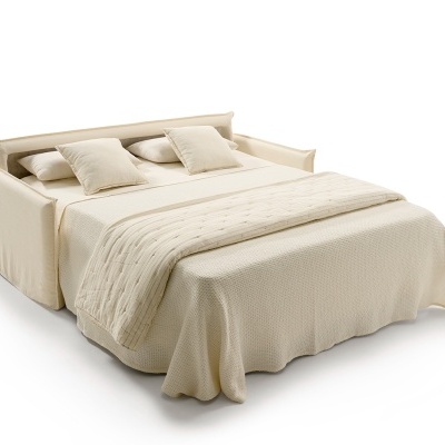 Sofá-cama bege com almofadas e manta texturizada