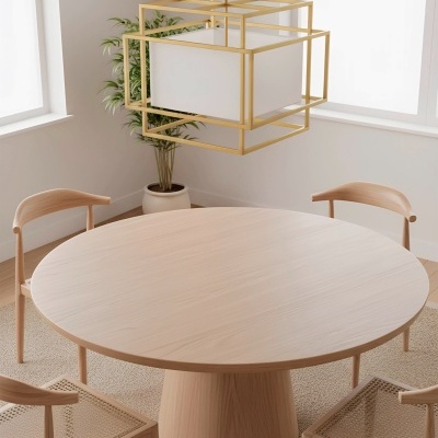 Mesa de jantar redonda de madeira clara com quatro cadeiras e candeeiro suspenso dourado numa sala luminosa.