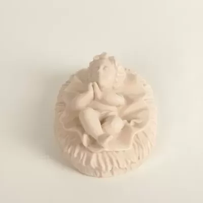 Estatueta de bebé ajoelhado com mãos em oração de cor bege