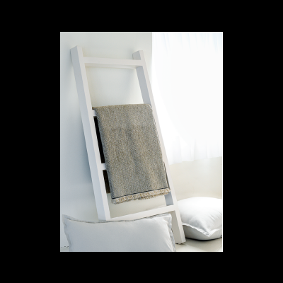 Escada decorativa branca com tecido cinzento e almofadas brancas