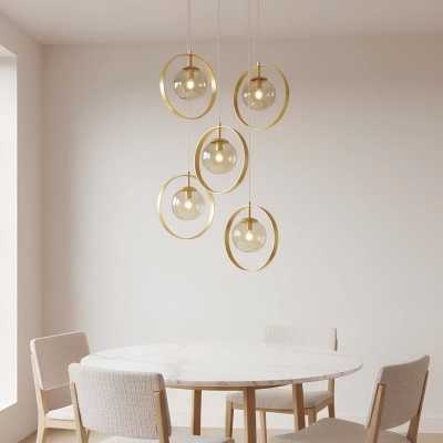 Conjunto de jantar com mesa redonda branca e quatro cadeiras bege, com candeeiros pendentes dourados