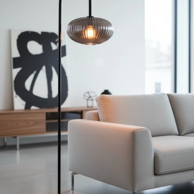 Candeeiro de pé com cúpula de vidro fumado ao lado de sofá cinza claro