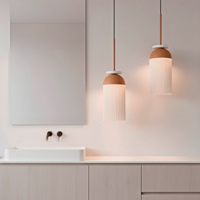 Casa de banho com lavatório branco, móveis de madeira clara, dois candeeiros suspensos castanhos com franja branca e um grande espelho retangular.