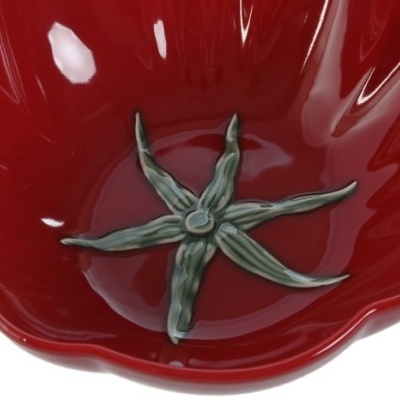 Taça vermelha em cerâmica com flor verde no centro