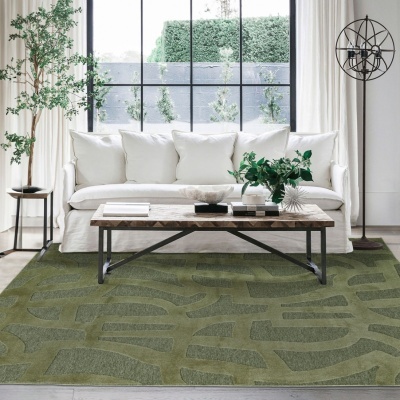 Tapete verde com padrão geométrico em sala de estar com sofá branco e mesa de centro