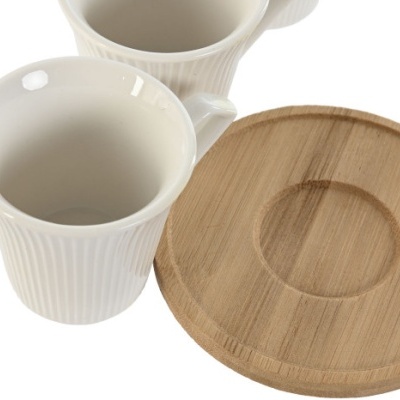 Duas chávenas brancas de cerâmica com padrão e suporte redondo de madeira clara