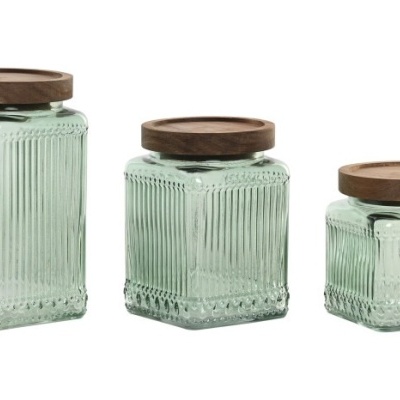 Três frascos quadrados de vidro verde com tampas de madeira