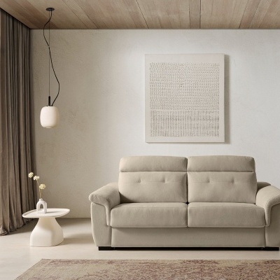 Sofá bege de três lugares com mesa lateral, candeeiro pendente e quadro decorativo em ambiente minimalista.