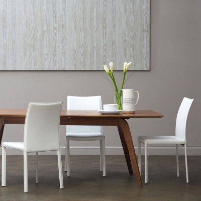 Mesa de madeira com cadeiras brancas e jarra com flores