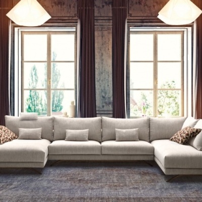 Sofá de canto bege claro com almofadas geométricas em sala clássica