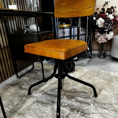 Cadeira com assento castanho e encosto de madeira numa sala com tapete branco.