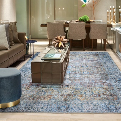 Sala de estar e jantar com tapete azul clássico, sofá castanho e mesa de centro em vidro