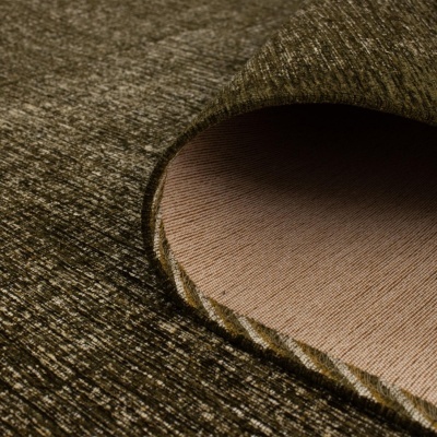 Tapete castanho escuro com canto enrolado mostrando o verso liso castanho claro