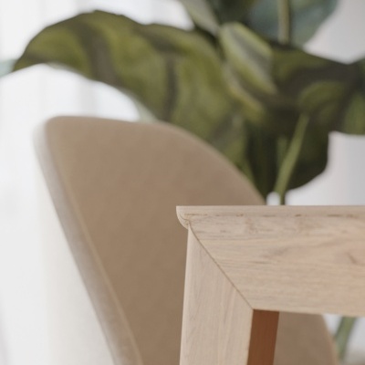 Cadeira estofada bege junto a mesa de madeira clara com folhas verdes ao fundo